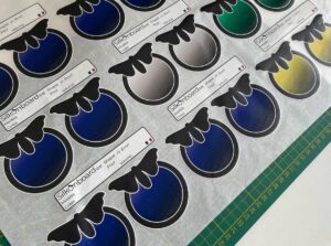 Impression numérique multicolore à l'unité de logos sur papier de soie, avec couleurs et blancs opaques.