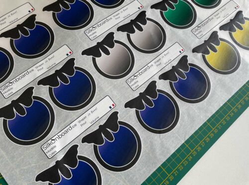 Impression numérique multicolore à l'unité de logos sur papier de soie, avec couleurs et blancs opaques.